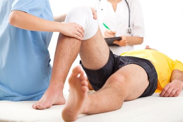 Der Arzt wählt nach einer diagnostischen Untersuchung ein Behandlungsschema für einen Patienten mit Arthrose aus.